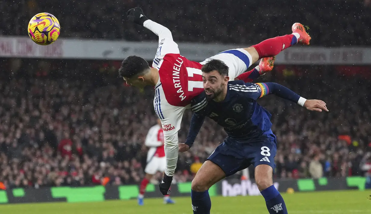 Pemain Arsenal, Gabriel Martinelli (atas) berduel udara dengan pemain Manchester United, Bruno Fernandes pada laga lanjutan Liga Inggris 2024/2025 di Emirates Stadium, London, Inggris, Kamis (05/12/2024) WIB. (AP Photo/Kirsty Wigglesworth)