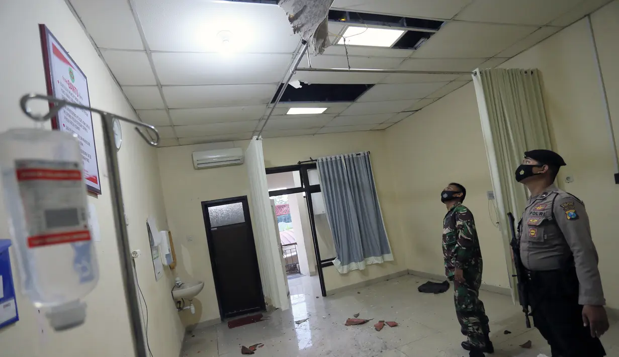 Polisi dan personel militer memeriksa kerusakan akibat gempa di rumah sakit Ngudi Waluyo, Blitar, Jawa Timur, Sabtu (10/4/2021). Gempa bermagnitudo 6,0 melanda lepas pantai pulau Jawa Indonesia pada Sabtu 10 April 2021. (Photo by M. ULIN NUHA / AFP)