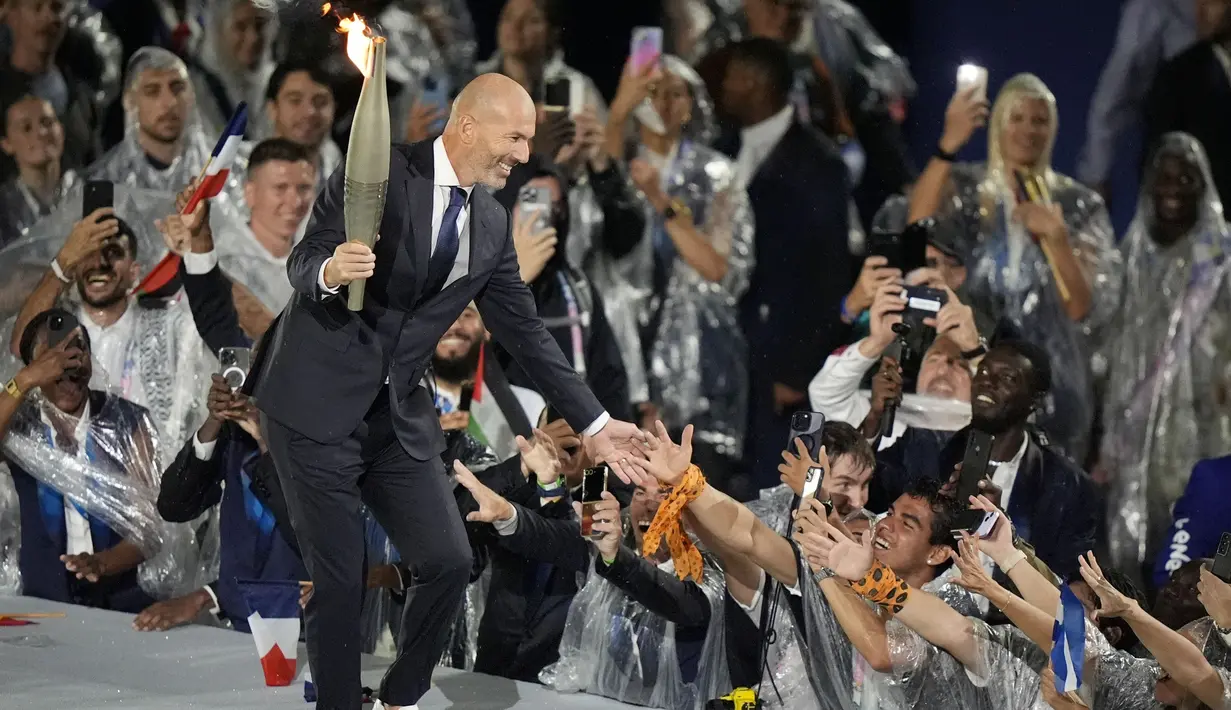 Legenda sepak bola Prancis, Zinedine Zidane, menyapa fans dalam acara pembukaan Olimpiade Paris 2024 di Sungai Seine, Prancis. (AP Photo/Frank Franklin II)