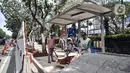 Pekerja menyelesaikan proyek revitalisasi trotoar di Jalan Medan Merdeka Selatan, Jakarta Pusat, Selasa (22/11/2022). Kepala Dinas Bina Marga DKI Jakarta Hari Nugroho mengatakan Rp 171 miliar RAPBD DKI Jakarta 2023 untuk membangun sekitar 20 kilometer trotoar di Ibu Kota. (merdeka.com/Iqbal S. Nugroho)