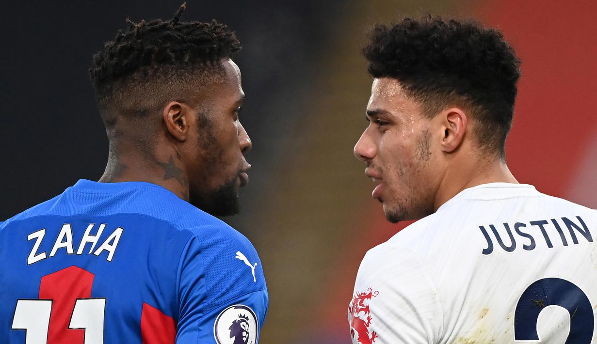 Striker Crystal Palace, Wilfried Zaha (kiri) bersitegang usai ditekel bek Leicester City, James Justin (kanan) dalam laga lanjutan Liga Inggris 2020/21 pekan ke-16 di Selhurst Park, Senin (28/12/2020). Crystal Palace bermain imbang 1-1 dengan Leicester City. (AFP/Facundo Arrizabalaga/Pool)
