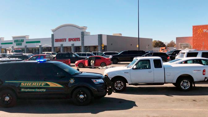 Polisi berjaga setelah penembakan di tempat parkir Walmart, Duncan, Oklahoma, Amerika Serikat, Senin (18/11/2019 ). Pihak berwenang belum mengungkapkan motif penembakan tersebut. (AP Photo/Sean Murphy)