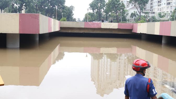 Petugas berada di dekat underpass Kemayoran yang terendam banjir di Jakarta, Minggu (2/2/2020). Banjir kembali merendam underpass Kemayoran, Jakarta Pusat. Akibatnya, akses jalur tersebut pun terputus alias tak bisa dilalui kendaraan. (Liputan6.com/Angga Yuniar)