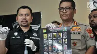 Kabid Humas Polda Metro Jaya Kombes Pol Argo Yuwono (kanan) dan Kepala Subdit II Ditresnarkoba Polda Metro Jaya AKBP Calvijn Simanjuntak menunjukkan hasil produksi liquid vape narkoba Reborn Cartel di Jakarta, Kamis (8/11). (Merdeka.com/Iqbal Nugroho)