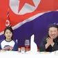 Pemimpin Korea Utara Kim Jong Un dan putrinya Ju Ae menghadiri jamuan makan di Paviliun Mulan di Pyongyang untuk merayakan peluncuran satelit mata-mata Malligyong-1. (Dok. KCNA melalui KNS/AFP)