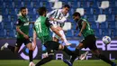 Striker Juventus, Cristiano Ronaldo (tengah) melepaskan tendangan di antara dua pemain Sassuolo dalam laga lanjutan Liga Italia 2020/2021 pekan ke-36 di Mapei-Citta del Tricolore Stadium, Rabu (12/5/2021). Juventus menang 3-1 atas Sassuolo. (AFP/Marco Bertorello)