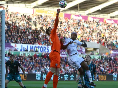 Kiper Southampton, Alex McCarthy menghalau bola dari kejaran pemain Swansea, Andre Ayew pada lanjutan Premier League di Liberty Stadium, Swansea, (8/5/2018). Swasea City kalah dari Soton 0-1. (AFP/Geoff Caddick)