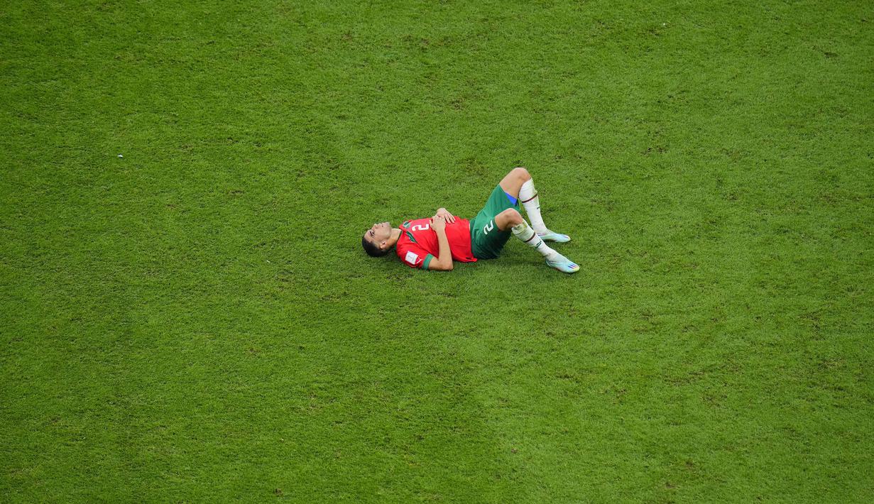 Reaksi kecewa pemain Maroko, Achraf Hakimi setelah kalah dari Prancis pada laga semifinal Piala Dunia 2022 yang berlangsung di Al Bayt Stadium, Qatar, Rabu (14/12/2022) waktu setempat. Prancis menang dengan skor 2-0 melalui gol Theo Hernandez dan Randal Kolo Muani. (AP Photo/Hassan Ammar)