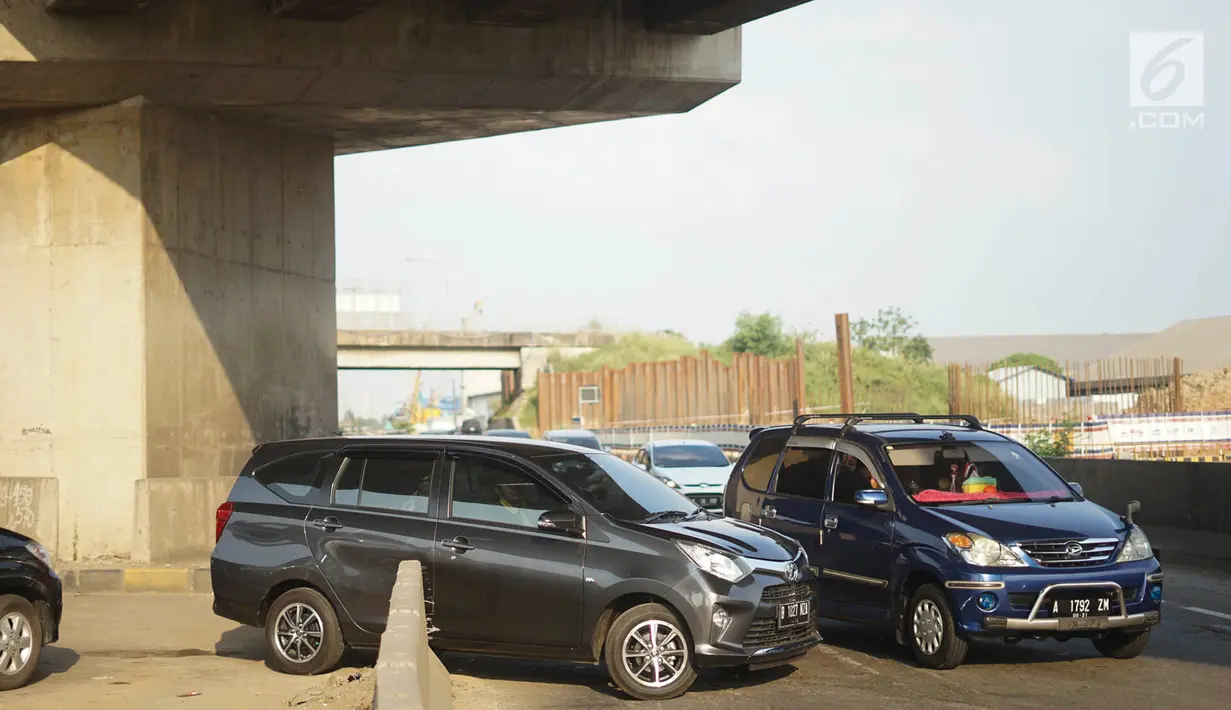 Pengendara mobil menerobos pagar pembatas jalan tol di KM 30 Tol Jakarta - Cikampek, kawasan Cikarang, Jawa Barat, Minggu (9/6). Kemacetan yang terjadi di sepanjang jalur tersebut menyebabkan sebagian kendaraan nekat menerobos pagar pembatas untuk berpindah jalur. (Liputan6.com/Immanuel Antonius)
