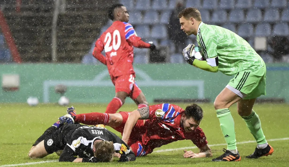 Kiper Bayern Munich, Manuel Neuer (kanan) menangkap bola dari ancaman gelandang tim Divisi 2 Holstein Kiel, dalam laga babak kedua Piala DFB Pokal 2020/21 di Kiel, Rabu (13/1/2021). Bayern Munich kalah dari Holstein Kiel lewat adu penalti 5-6 (2-2). (AFP/Fabian Bimmer/Pool)