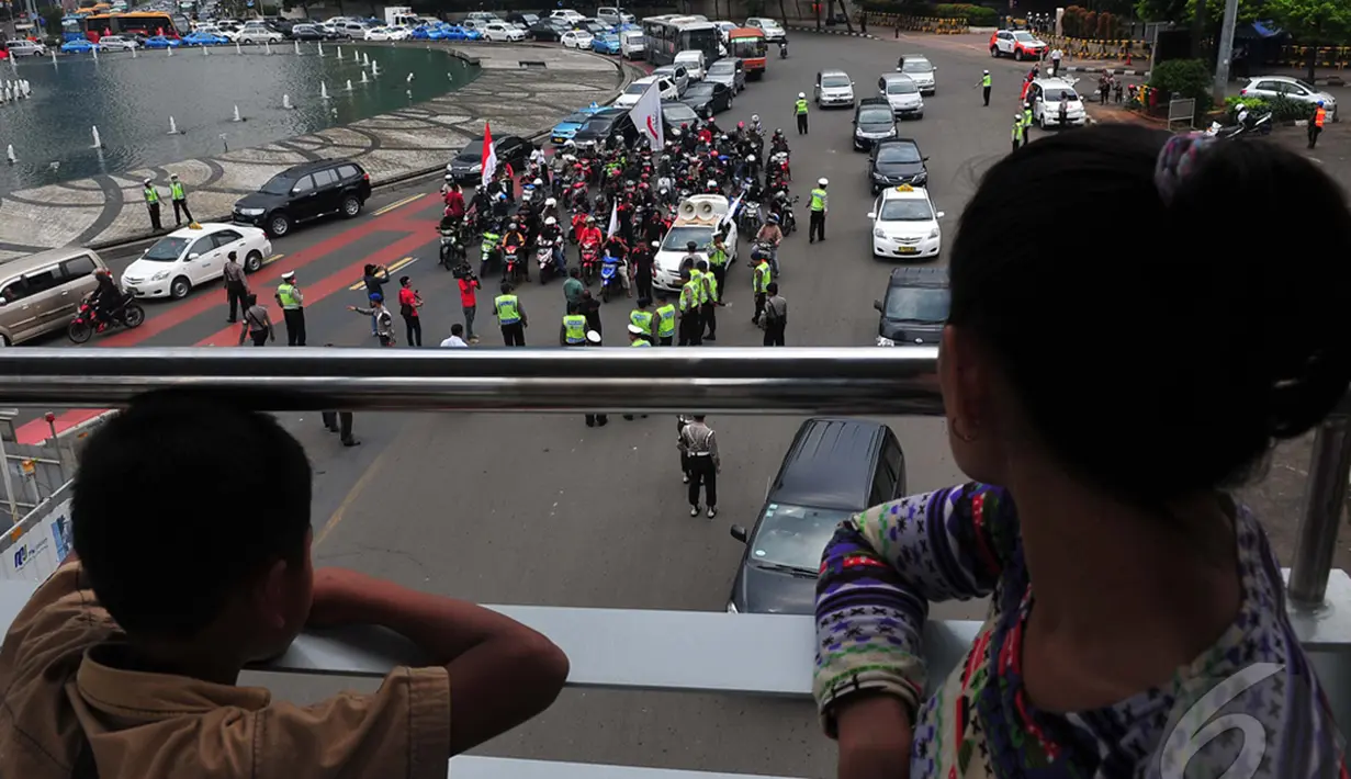 Pejalan kaki saat melihat aksi pengendara sepeda motor di Bundaran HI, Jakarta, Minggu (22/12/2014) (Liputan6.com/Johan Tallo)