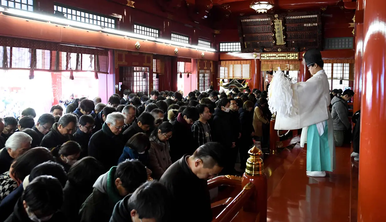 Seorang imam Shinto berdoa bersama pengusaha selama upacara awal tahun di Kuil Kanda Myojin, Tokyo (4/1). (AFP Photo/Toshifumi Kitamura)