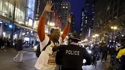 Dontreal Widow (kiri) melakukan aksi protes di Chicago, Illinois, Rabu (25/11). Ketegangan rasial memanas setelah rilisnya video kejadian seorang polisi kulit putih menembak remaja kulit hitam Laquan McDonald (17) pada Oktober 2014 (REUTERS/Andrew Nelles)
