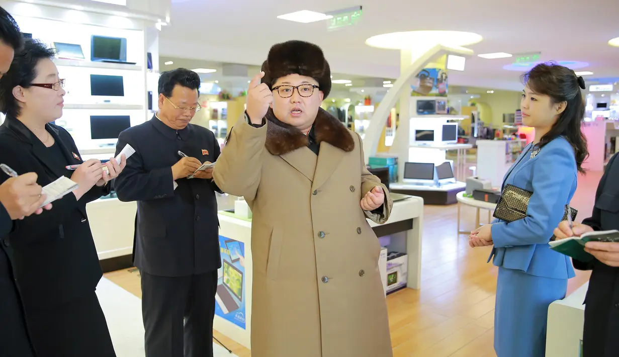 Kim Jong-un tampak menyampaikan sesuatu kepada sejumlah stafnya saat melakukan kunjungan dan keliling ke pusat perbelanjaan Mirae Shop yang baru dibangun di kompleks Mirae Shop di Korea Utara (28/3). (REUTERS/KCNA)