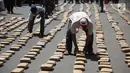 Petugas merapikan barang bukti ganja sebanyak 1.300 paket di Polres Jakarta Barat, Kamis (4/1). Modus penyelundupan ganja disimpan di balik tumpukan karung arang kayu yang sudah dimodifikasi dengan dilapisi baja ringan. (Liputan6.com/Arya Manggala)