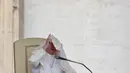 Paus Fransiskus saat memberikan ceramah di hadapan publik di alun-alun Santo Petrus, Vatikan (26/4). Tiupan angin membuat wajah Paus Fransiskus tertutup jubah yang ia kenakan. (AFP Photo / Vicenzo Pinto)