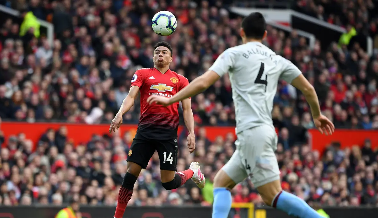 Gelandang Manchester United, Jesse Lingard berusaha mengontrol bola dari kawalan bek West Ham United, Fabián Balbuena selama pertandingan lanjutan Liga Inggris di Old Trafford (13/4). MU menang tipis atas West Ham 2-1. (AFP Photo/Paul Ellis)