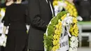 Perdana Menteri Jepang Shinzo Abe membawa karangan bunga pada saat upacara peringatan 70 tahun jatuhnya bom atom di Hiroshima, Jepang (6/8/2015). 140.000 penduduk Jepang tewas akibat Bom Atom. (REUTERS/Kyodo)