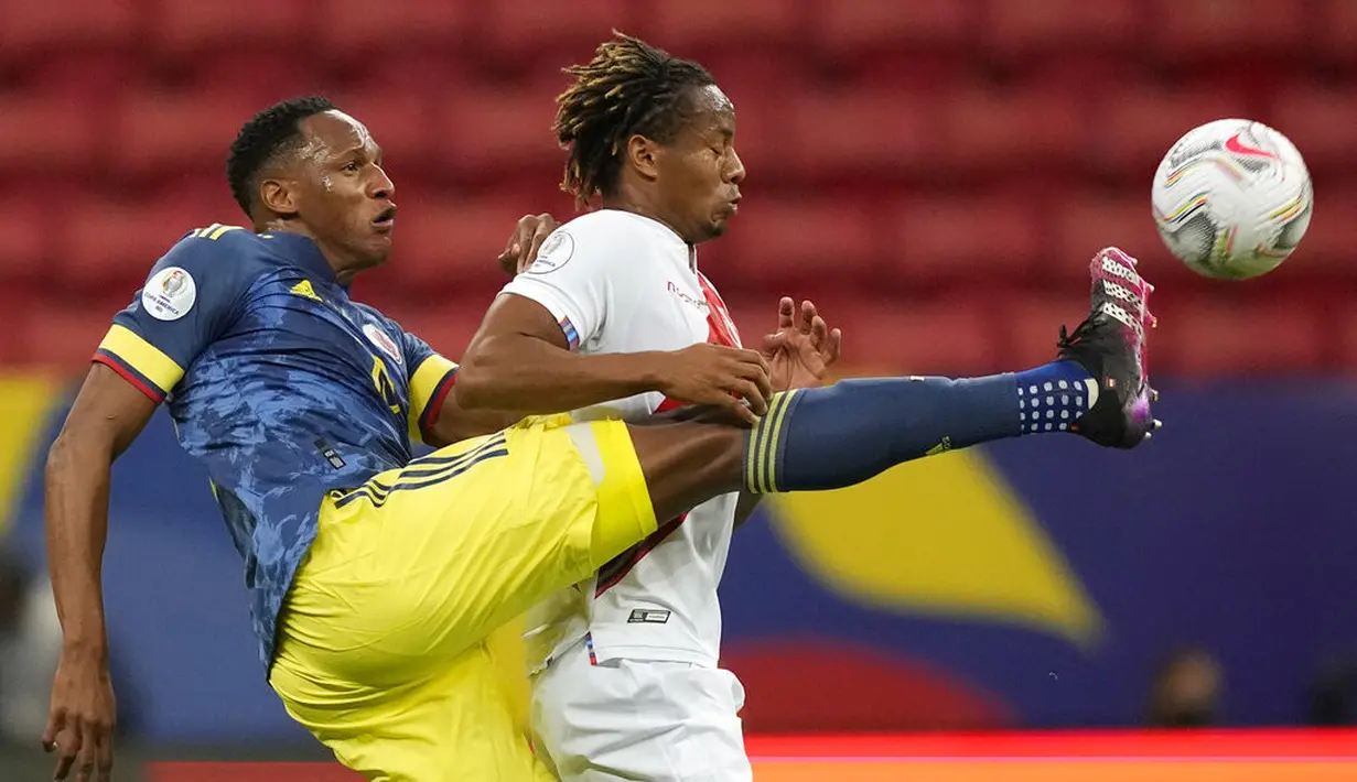 Gelandang Kolombia, Yerry Mina berebut bola dengan pemain Peru, Andre Carrillo pada pertandingan juara ketiga Copa America 2021 di Stadion Nasional Brasilia, Brasil, Sabtu (10/7/2021). Kolombia menang dramatis 3-2 atas Peru. (AP Photo/Eraldo Peres)