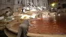 Petugas membersihkan air mancur Trevi di Roma, Italia usai aksi seorang pria menuangkan pewarna merah, 26 Oktober 2017. Pejabat Kota Roma mengecek lokasi untuk memastikan apakah ada kerusakan di tempat wisata dari abad ke-18 ini. (Filippo MONTEFORTE/AFP)