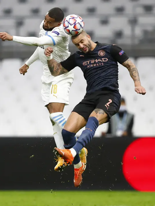 Bek Manchester City, Kyle Walker berebut bola dengan pemain Marseille, Jordan Amavi pada pertandingan grup C Liga Champions di Stade Velodrome di Marseille, Prancis, Selasa (27/10/2020). City menang telak 3-0 atas Marseille. (Guillaume Horcajuelo/Pool via AP)