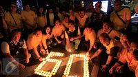 Sejumlah karyawan Artha Graha mengikuti aksi "Earth Hour" dengan menyalakan lilin membentuk angka 60 di kawasan SCBD Jakarta saat lampu-lampu di kawasan itu mulai dipadamkan selama satu jam pada Sabtu malam (19/3/2016). (Foto: Istimewa)