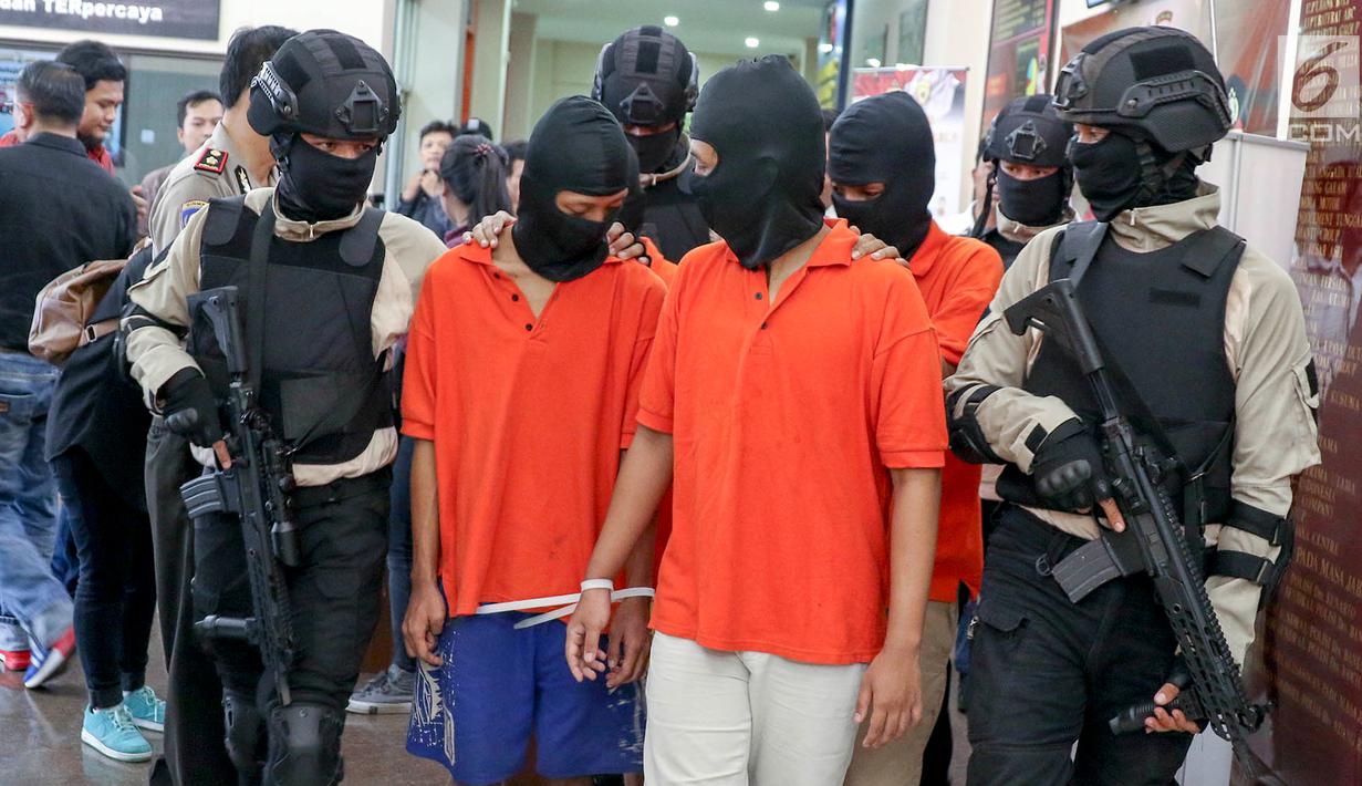 Polisi menggiring tersangka kasus begal di Mapolres Metro Jakarta Selatan, Selasa (17/7). Polisi mengamankan barang bukti sebilah pedang, sebilah pisau, telepon selular, dan dua unit sepeda motor. (Liputan6.com/Immanuel Antonius)