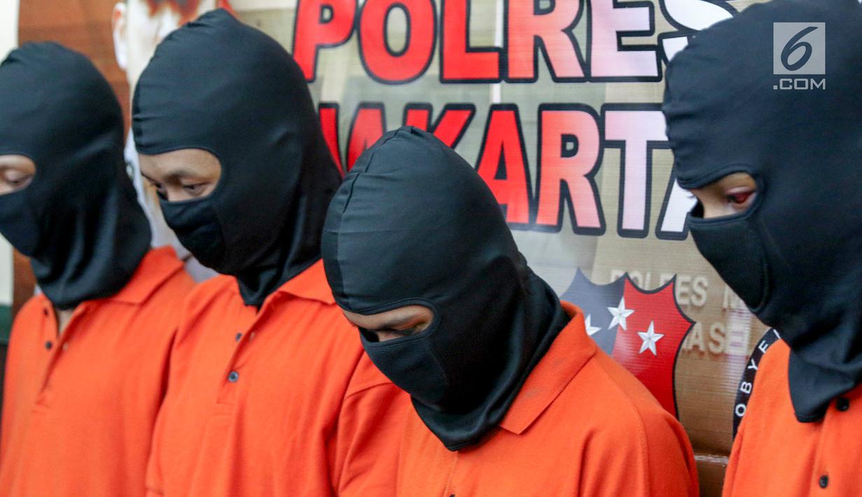 Para tersangk tertunduk saat polisi rilis kasus begal di Mapolres Metro Jakarta Selatan, Selasa (17/7). Polisi mengamankan barang bukti sebilah pedang, sebilah pisau, telepon selular, dan dua unit sepeda motor. (Liputan6.com/Immanuel Antonius)