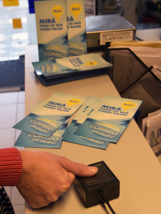 Seorang wanita mendaftarkan diri sebagai konsumen ganja di kantor pos ibu kota Urugay, Montevideo, Selasa (2/5). Pengguna harus mendaftarkan diri ke pemerintah untuk memastikan konsumsi ganja mereka tidak lebih dari 40 gram per bulannya. (MIGUEL ROJO/AFP)