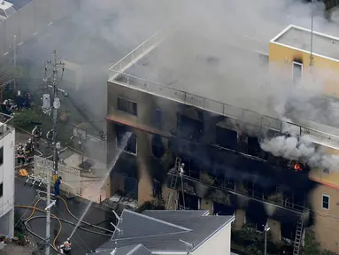 Asap mengepul saat kebakaran melanda studio animasi Kyoto Animation di Kyoto, Jepang, Kamis (18/7/2019). Sebanyak 13 orang diduga tewas dan puluhan lainnya luka-luka akibat kebakaran tersebut. (Kyodo News via AP)