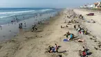 Pemandangan udara dari orang-orang di pantai di Playas de Tijuana dekat perbatasan AS-Meksiko di Tijuana, negara bagian Baja California, Meksiko, Sabtu (3/10/2020). Akhir pekan ini pantai di Playas de Tijuana dibuka kembali setelah ditutup sejak Maret lalu akibat Covid-19. (Guillermo Arias/AFP)