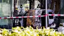 Petugas berdiri dekat mobil van yang menabrak pintu depan gedung tempat surat kabar ternama Belanda, De Telegraaf di Amsterdam, Selasa (26/6). Polisi kini tengah melakukan pencarian pelaku demi mengungkap motif di insiden itu. (KOEN VAN WEEL/ANP/AFP)