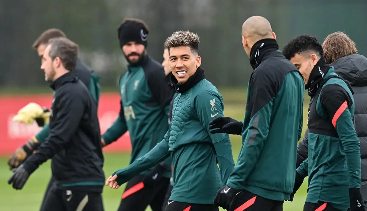 Pemain Liverpool Roberto Firmino (tengah) tiba untuk menghadiri sesi latihan jelang melawan Benfica pada pertandingan leg kedua perempat final Liga Champions di tempat latihan Liverpool FC di Liverpool, Inggris, 12 April 2022. Liverpool. (Paul ELLIS/AFP)