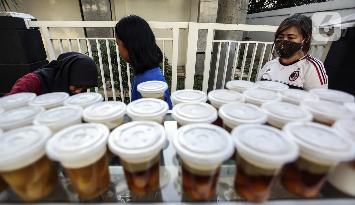 Pembeli melihat-lihat menu berbuka puasa atau takjil jelang waktu berbuka puasa di kawasan Radio Dalam, Jakarta Selatan, Senin (4/4/2022). Pedagang musiman yang menjual aneka takjil memanfaatkan momen bulan suci Ramadhan 1443 H. (Liputan6.com/Johan Tallo)
