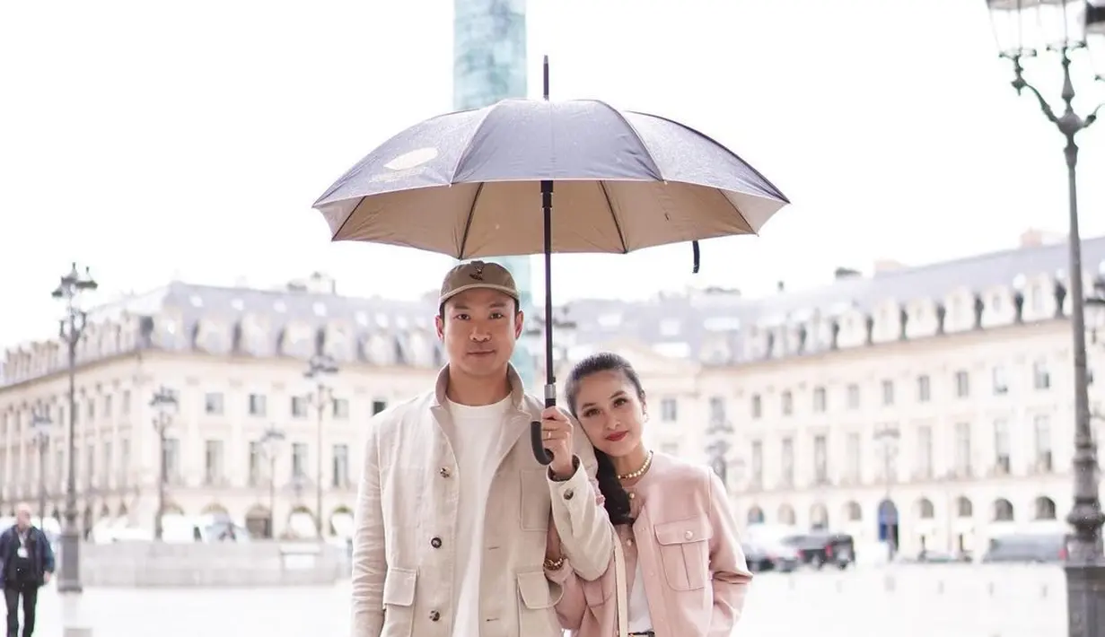 <p>Pose mesra di bawah payung, Harvey dan Sandra terlihat serasi kenakan pocket jacket sesuai personal style masing-masing. [@sandradewi88]</p>