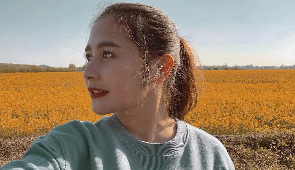 Cewek cantik yang lahir di Tangerang ini tampil cantik saat liburan ke London. Berpose dengan latar belakang padang bunga berwarna kuning, ia tampak memesona dengan rambut yang diikat ke belakang.  (Liputan6.com/IG/@prillylatuconsina96)