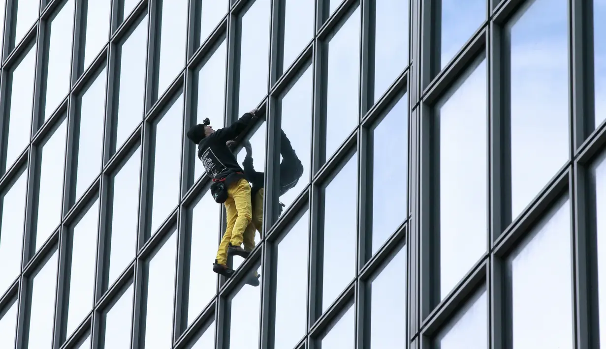 Alain Robert ketika memanjat gedung di pusat bisnis La Defense, Paris, Prancis, Senin (21/3/2016). Pria yang dijuluki 'Spiderman' ini telah memanjat lebih dari 70 gedung tertinggi di dunia. (Jacques DEMARTHON/AFP)