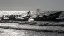 Seorang nelayan Palestina melempar tali dari perahu ke perahu lain saat menangkap ikan di Laut Mediterania, Rafah, Jalur Gaza, Rabu (2/9/2020). (SAID KHATIB/AFP)