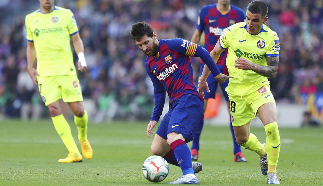 Striker Barcelona, Lionel Messi, berusaha melewati pemain Getafe, Mauro Arambarri, pada laga La Liga di Stadion Camp Nou, Sabtu (15/2/2020). Barcelona menang 2-1 atas Getafe. (AP/G.Garin)
