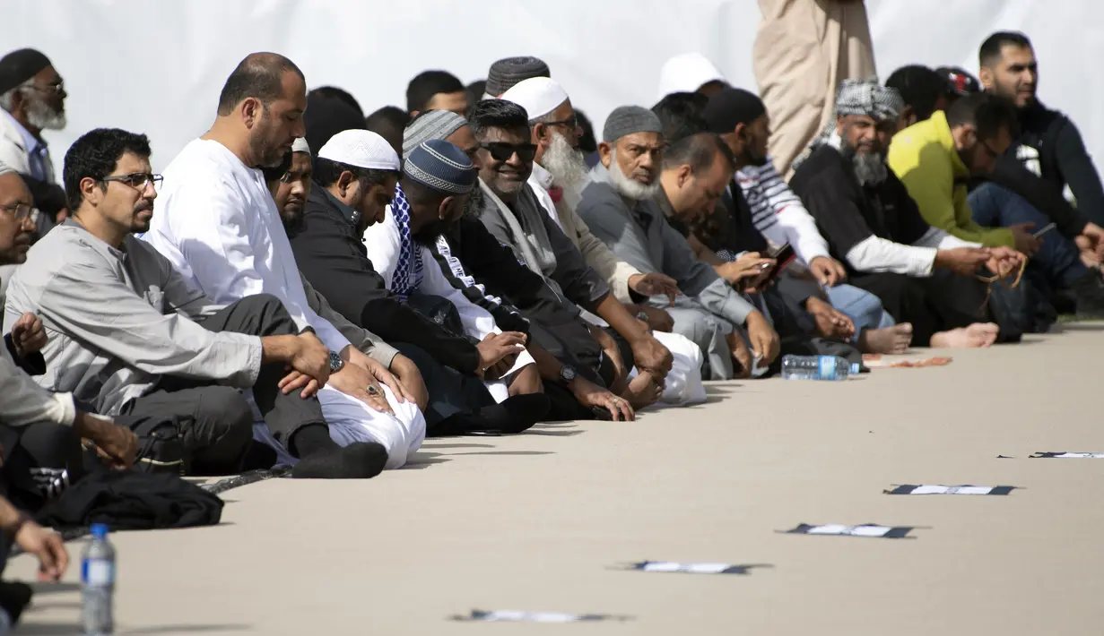 Umat muslim menghadiri pelaksanaan salat Jumat di Hagley Park, Kota Christchurch, Selandia Baru, Jumat (22/3). Salat Jumat digelar di seberang Masjid Al Noor yang menjadi salah satu lokasi insiden teror pada 15 Maret lalu. (Marty MELVILLE / AFP)