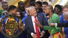 Presiden Donald Trump berbicara dengan kiper Chelsea Robert Sanchez saat Reece James memegang trofi juara setelah laga final Piala Dunia Antarklub antara Chelsea dan PSG di MetLife Stadium, New Jersey, 13 Juli 2025. (AP Photo/Jacquelyn Martin)