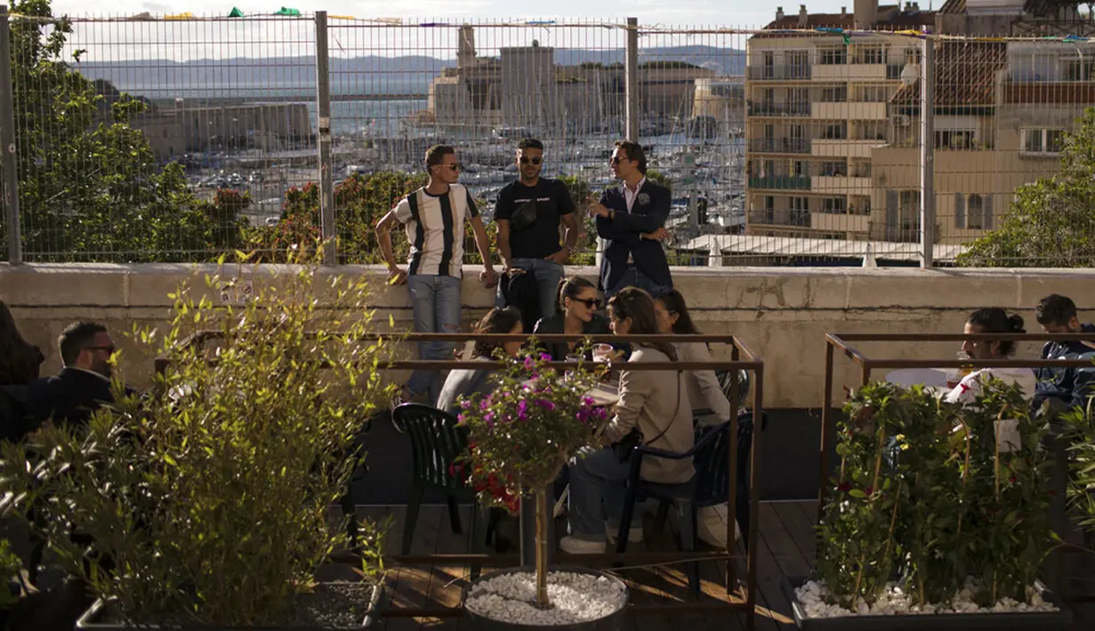 Warga minum bir di teras bar di Marseille, Prancis, Rabu (19/5/2021). Prancis kembali membuka kafe dan restoran pada 19 Mei 2021 setelah ditutup lebih dari enam bulan karena pandemi virus corona COVID-19. (AP Photo/Daniel Cole)