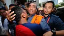 Bupati Buton nonaktif, Samsu Umar Abdul Samiun dipeluk kerabatnya usai menjalani pemeriksaan di Gedung KPK, Jakarta, Kamis (26/1). Samsu Umar tersangka dugaan suap Ketua Mahkamah Konstitusi Akil Mochtar, Oktober 2016. (Liputan6.com/Helmi Fithriansyah)