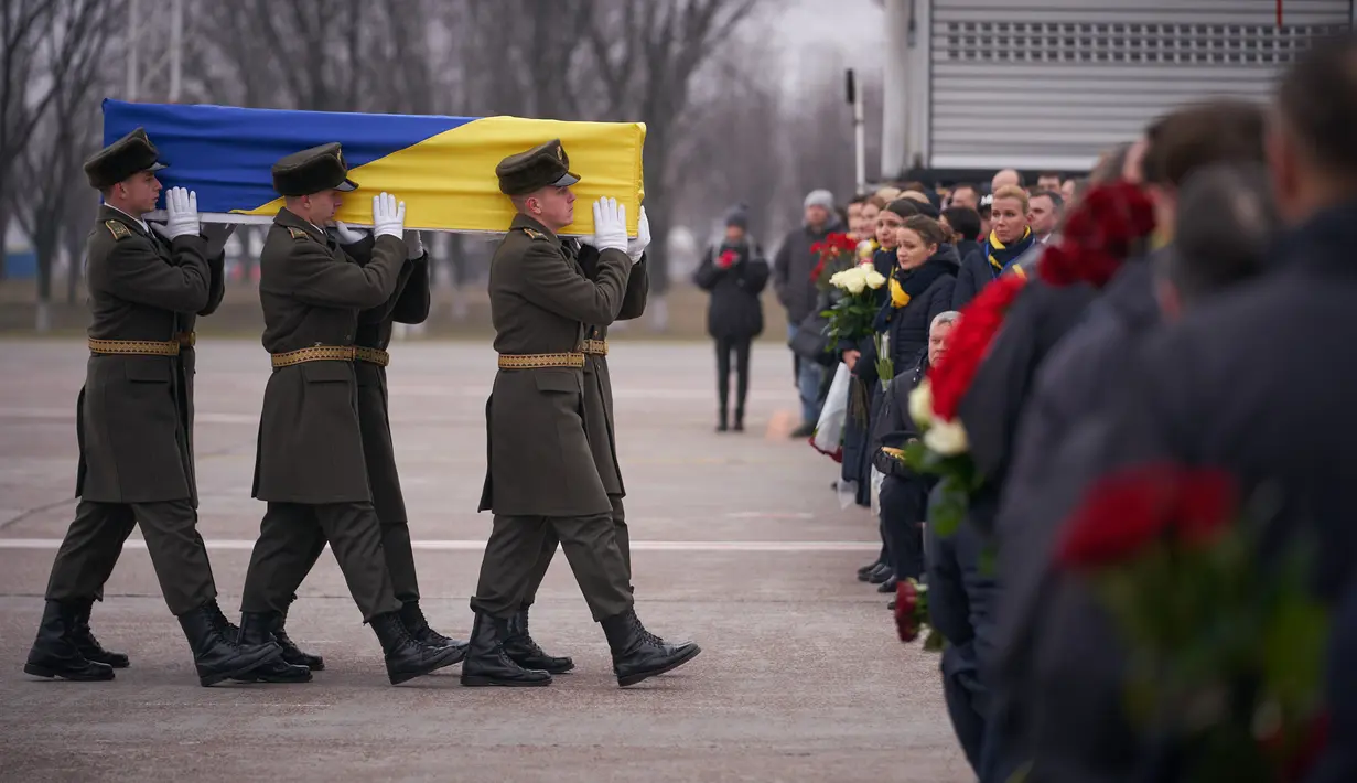 Prajurit Penjaga Kehormatan membawa jenazah 11 warga Ukraina yang tewas dalam insiden jatuhnya pesawat Ukraine International Airlines di Iran (8/1) lalu, Bandara Boryspil Kiev, Ukraina, Minggu (19/1/2020). 176 penumpang dan awak tewas dalam tragedi tersebut.(Ukrainian Presidential Press Service/AFP)