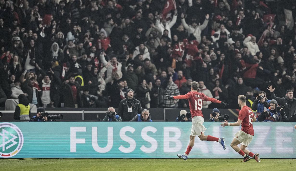 Selebrasi striker Timnas Turki, Kenan Yildiz (kiri) setelah mencetak gol kedua ke gawang Timnas Jerman pada laga uji coba internasional di Olympiastadion, Berlin, Minggu (19/11/2023) dini hari WIB. (AP Photo/Markus Schreiber)