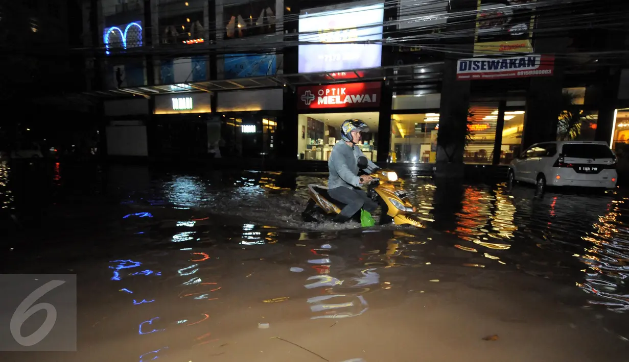 Seorang pengendara motor menerobos banjir yang menggenangi kawasan Kemang, Jakarta, Minggu (25/9). Hujan deras yang mengguyur sebagian besar kawasan di Jakarta, Minggu malam, membuat wilayah Kemang terendam banjir lagi. (Liputan6.com/Helmi Afandi)