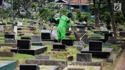 Petugas harian Sudin Kehutanan Jakpus membersihkan makam di Tempat Pemakaman Umum (TPU) Utan Jati, Kamis (11/1). Pemprov DKI membutuhkan lahan makam seluas 794 hektare, tapi hingga kini baru tersedia sekitar 611 hektare. (Liputan6.com/Faizal Fanani)