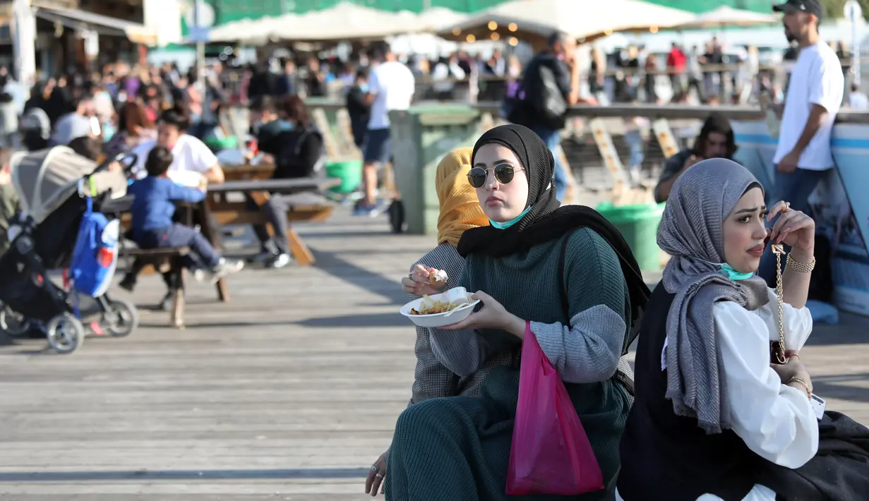 Sejumlah orang bersantai di Tel Aviv, Israel, pada 26 Desember 2020. Karantina wilayah (lockdown) penuh ketiga akan diberlakukan secara nasional di Israel mulai Minggu (27/12) pukul 17.00 waktu setempat. (Xinhua/JINI/Gideon Markowicz)