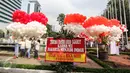 Balon merah putih dan karangan bunga terlihat di halaman Balai Kota DKI Jakarta, Senin (8/5). Di setiap ikat balon terdapat tulisan untuk menyemangati Basuki Tjahaja Purnama atau Ahok dan Djarot Saiful Hidayat. (Liputan6.com/Faizal Fanani)