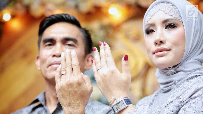 Aktris Shinta Bachir bersama anggota DPRD Sidrap, Idham Masse memperlihatkan cincin saat acara lamaran di kawasan Bambu Apus, Jakarta, Sabtu (8/9). Shinta Bachir (32) tampil anggun sambil mengenakan pakaian serba abu-abu. (Liputan6.com/Faizal Fanani)